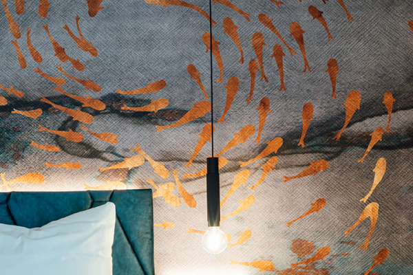 Galeriebild VEMA_2379.jpg Tapete mit orangefarbenen Fischen und einer hängenden Lampe über einem Bett.