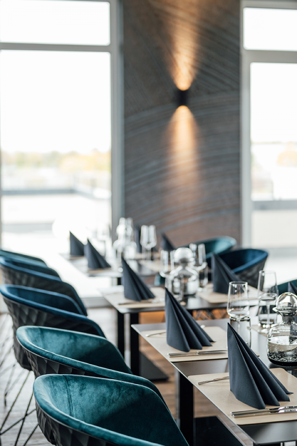 Galeriebild VEMA_3264.jpg Ein elegantes Restaurant mit blauen Stühlen, gedeckten Tischen und dekorativen Servietten.