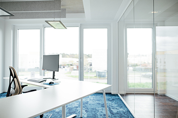 Galeriebild VEMA_3843.jpg Ein modernes Büro mit einem Schreibtisch, einem Computer und großen Fenstern.