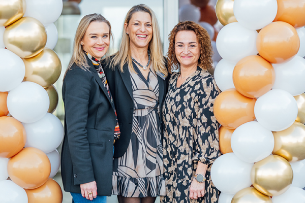 Galeriebild VEMA_4113.jpg Drei Frauen stehen lächelnd vor einer bunten Ballonkulisse.