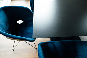 Galeriebild VEMA_4351.jpg Schwarzer Tisch und blaue Sessel in einem modernen Raum.
