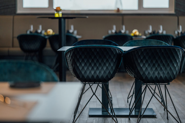 Galeriebild VEMA_5108.jpg Innenansicht eines stilvollen Restaurants mit schwarzen, gepolsterten Stühlen und Tischen.