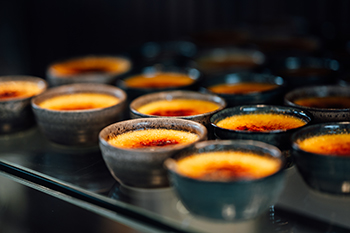 Galeriebild VEMA_5216.jpg Eine Reihe von kleinen Schalen mit Crème brûlée.
