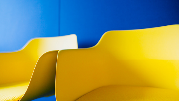 Galeriebild VEMA_6431.jpg Zwei gelbe Stühle vor einer blauen Wand.