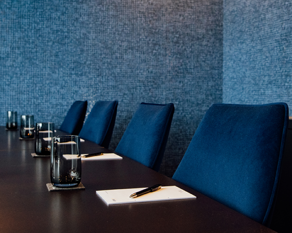 Galeriebild VEMA_6997-2.jpg Ein Konferenzraum mit blauen Stühlen, einem langen Tisch, Gläsern und Schreibunterlagen.