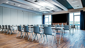 Galeriebild VEMA_7393-2.jpg Ein moderner Besprechungsraum mit Tischen, Stühlen und Fenstern, die viel Licht bieten.