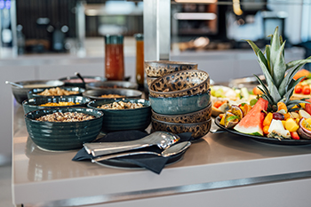 Galeriebild VEMA_8408.jpg Ein Buffet mit verschiedenen Schalen, darunter Obst, Müsli und Getränke.
