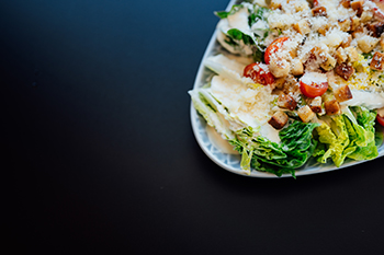 Galeriebild VEMA_9267.jpg Ein Teller mit Caesar-Salat, bestehend aus Salatblättern, Kirschtomaten, Croutons und Parmesan.