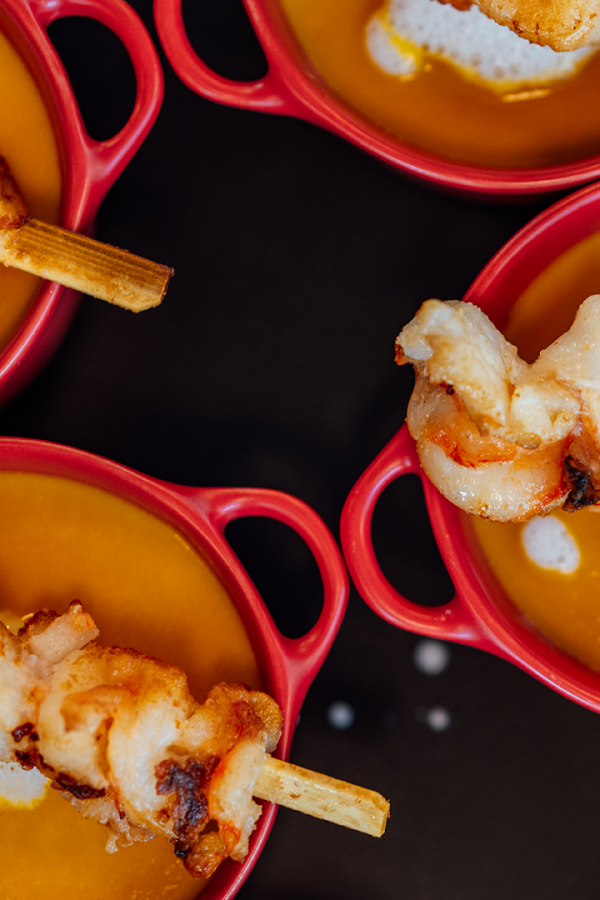 Galeriebild VEMA_9433.jpg Vier rote Schalen mit cremiger Suppe und gegrillten Spe skewers.