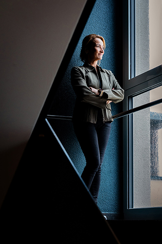 Galeriebild VEMA_NADINE_8301.jpg Eine Frau steht an einem Fenster und blickt nach draußen.